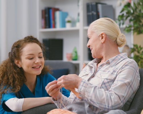 Friendly nurse checking up on a senior woman, home care services, assisted living